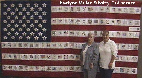 Evelyne Miller and Patty DiVincenzo standing in front of a flag quilt with a blue field of stars